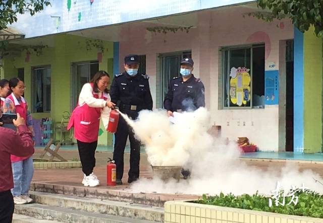 公安民警變身“消防安全老師”，指導(dǎo)幼兒園老師使用滅火器。